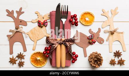 New year set of fork and knife on napkin. Top view of christmas decorations and reindeer on wooden background. Holiday family dinner concept with empt Stock Photo