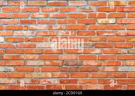 Weathered old brick wall surface. Aged red and orange brick cement wall architecture background. Brickwork texture Stock Photo