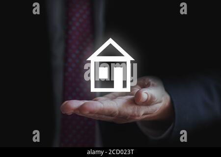 loan or real estate concept. Businessman holding home model. holding home for selling and buying strategy Stock Photo