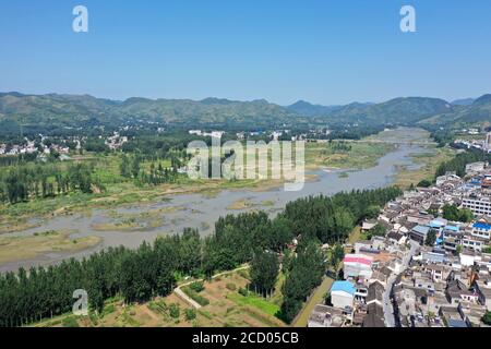Nanyang. 25th Aug, 2020. Aerial photo taken Aug. 25, 2020 shows a view of Jingziguan Township and Danjiang River, in Xichuan County, central China's Henan Province. Jingziguan Township is located on the border of Henan, Hubei and Shaanxi provinces. The ancient street here is a former trade center and boasts hundreds of well-preserved ancient buildings dating back to the Ming Dynasty (1368-1644) and the Qing Dynasty (1644-1911). Credit: Feng Dapeng/Xinhua/Alamy Live News Stock Photo