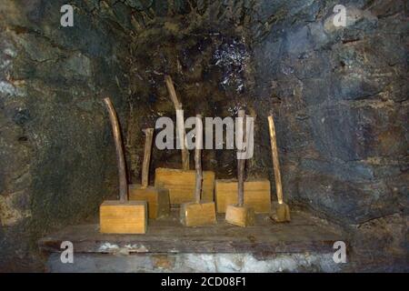 Multiple old hammers with stick handles and a wooden block hammer head Stock Photo