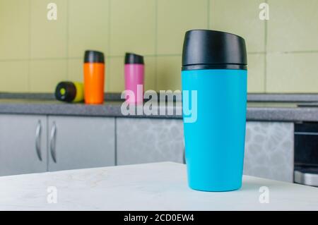 Blue thermo mug on the table in the kitchen. Stock Photo