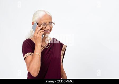 Elderly Indian lady speaking on her phone. Senior woman using her mobile phone. Stock Photo