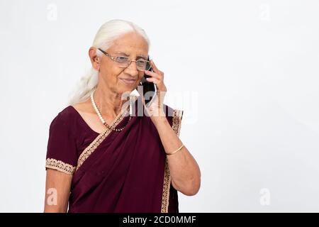Elderly Indian lady speaking on her phone. Senior woman using her mobile phone. Stock Photo