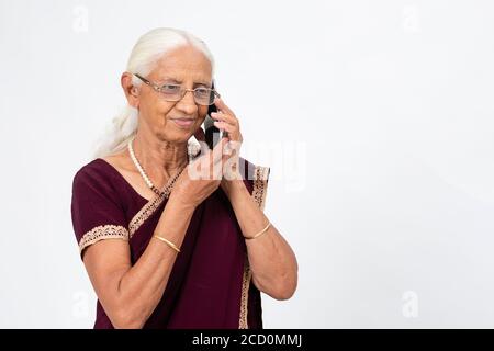 Elderly Indian lady speaking on her phone. Senior woman using her mobile phone. Stock Photo