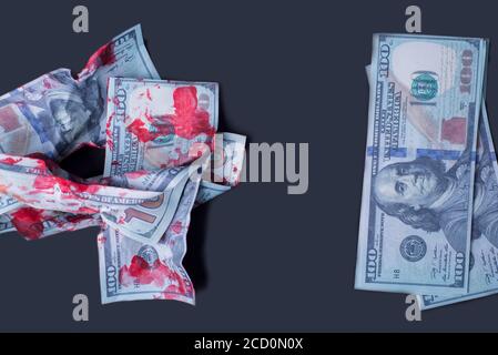 on a black background close-up crumpled bloodied dollar bills next to new money Stock Photo