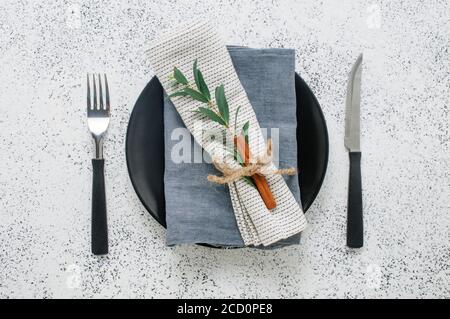 Holiday elegant table setting with linen napkin, sprig and cinnamon. Top view, flat lay. Stock Photo