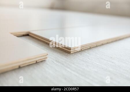 Engineered wood floor installation with subfloor membrane in condo. Maple hardwood flooring planks closeup showing composite plywood layers Stock Photo