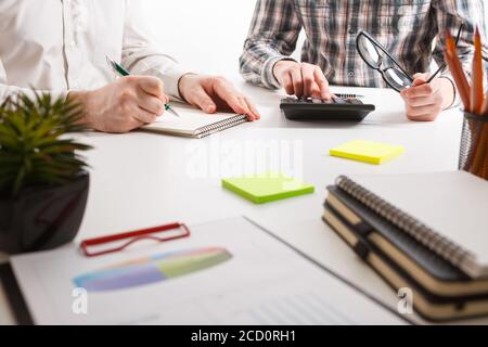 Documents with chart and graph and pen on background of two employees working Stock Photo
