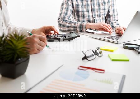 Documents with chart and graph and pen on background of two employees working Stock Photo