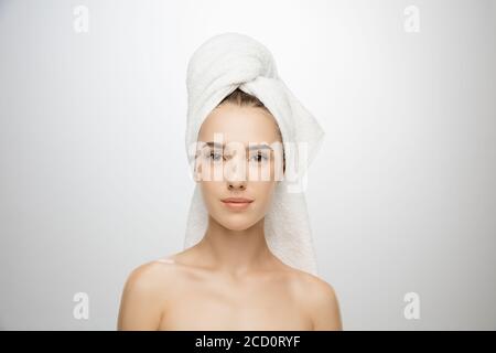 Beauty Day. Woman wearing towel isolated on white studio background. Day for self-care, skin-care, beauty routine. Beautiful caucasian female model with well-kept skin. Concept of spa, treatment. Stock Photo