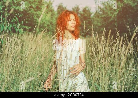 Woman standing in dry tall grass Stock Photo