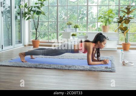 Workout at home. Young asian woman doing working out at home and doing plank. Stock Photo