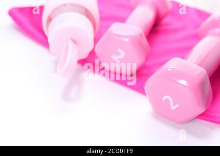 pink color dumbbell and water bottle on a towel on table  Stock Photo