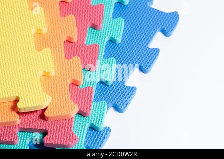 Macro photo of the details of a foam eva isolated on white background. Colored rubber mat puzzle for children. Stock Photo