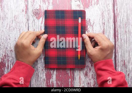 high angle view of notepad and pencil on wooden background  Stock Photo