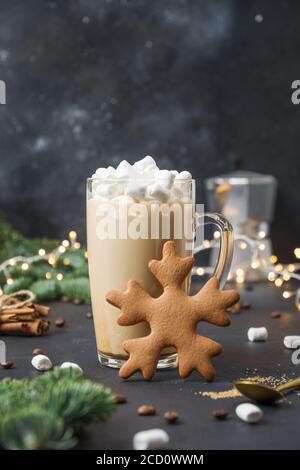 Christmas coffee with marshmallow and gingerbread shape of snowflake on dark background decorated garland. Stock Photo