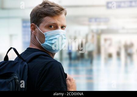 young man wearing disposable face mask at airport terminal during virus pandemic Stock Photo