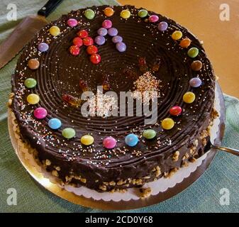 Chocolate birthday cake for eleventh birthday. Decorated with colored chocolate drops and colored sprinkles. Stock Photo