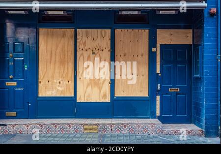 Windows boarded up on a building during national lockdown in London during the Covid-19 Global Pandemic; London, England Stock Photo