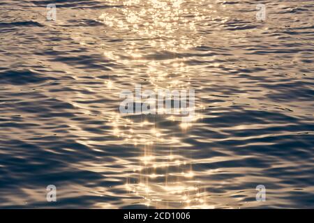 Ocean water texture in sunlight. Slight flow and light wind on water surface. Sunny natural ocean surface background. Wanderlust copy space Stock Photo