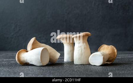 Raw king oyster mushrooms on dark background Stock Photo