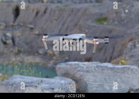 Flying quadcopter with a digital camera on a blurred background Stock Photo