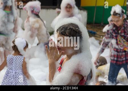 Kamennomostsky, Russia - September 1, 2018: Happy children having fun at a foam party at a holiday town day Kamennomostsky in an autumn park Stock Photo