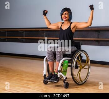 A paraplegic woman taking a break in a gymnasium after working out in a recreational facility: Sherwood Park, Alberta, Canada Stock Photo