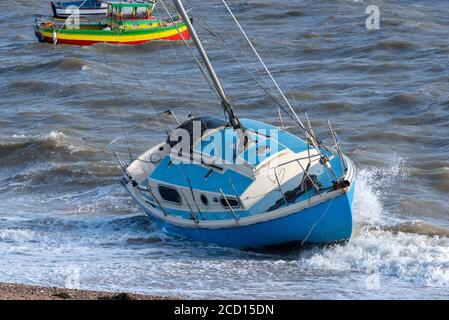 Southend on Sea, Essex, UK. 25th Aug, 2020. Storm Francis brought strong winds to the Thames Estuary and the coastline of Southend on Sea, with waves crashing against the beach. A yacht has been blown from its mooring onto the beach Stock Photo