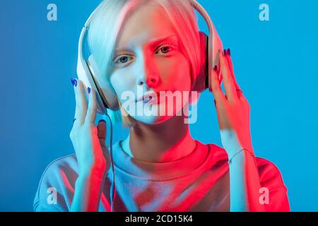 awesome Caucasian albino girl concentrated on music, close up photo. education, girl learning the language by the headphones, method of studing Stock Photo