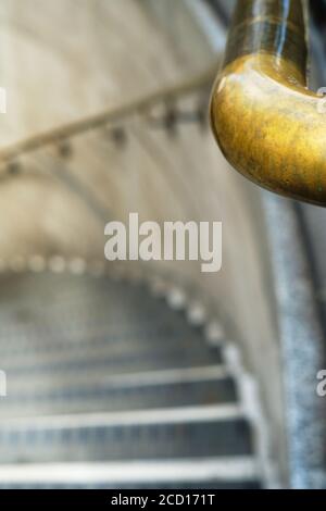 Perspective view of spiral stairs with gold handrail. Stock Photo