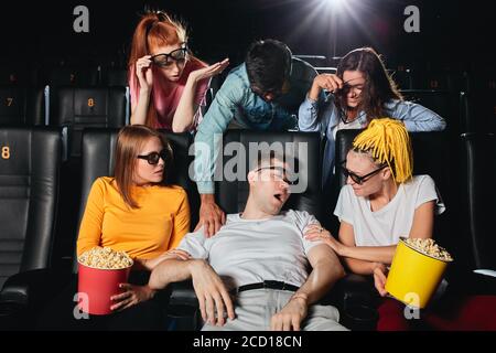 sleeping young man in 3d glasses disturbing his friends during the session, he is snoring loudly at the cinema Stock Photo