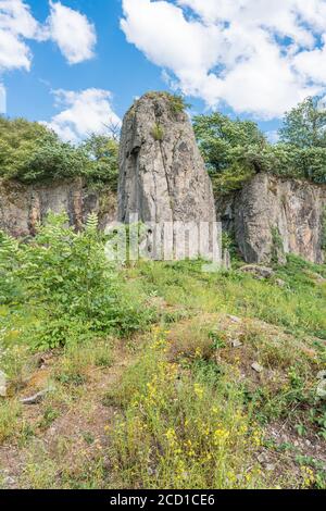 A pillar in front of a Rock face in the midday sun. Stock Photo