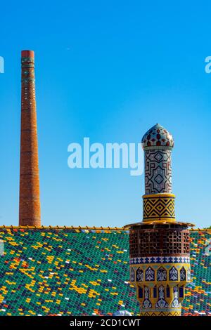 Pecs, Hungary - 21.08.2020: Beautiful colorful buildings in the famous Zsolnay quarter in Pécs with statue and decorated chimneys Stock Photo