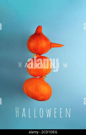 A snowman with a carrot nose of three orange pumpkins on a blue background. Halloween concept. Stock Photo