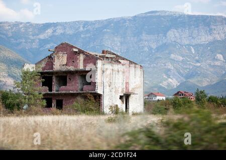 Destroyed and abandoned building on the field after the war of bombing. Old ruined house after bombing in Bosnia and Herzegovina. Bullet holes on the Stock Photo