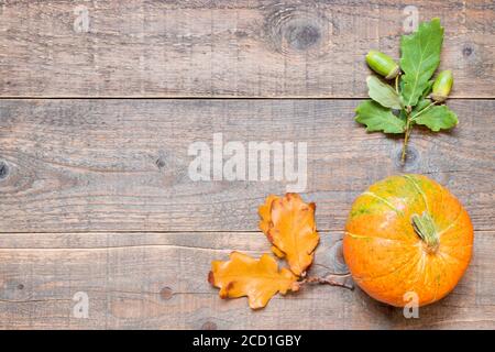 Autumn background with oak leaves and pumpkin. Minimalistic frame of fall harvest on aged timber with copy space. top view and flat lay Stock Photo