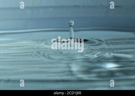 Small splash from a water drop on water surface creating ripples ripples Stock Photo