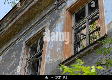 Detail of an old abandoned house. Moisture-damaged plaster. Old shabby cracked stucco. Dirty wall, grunge texture. Painted concrete, abstract damaged Stock Photo