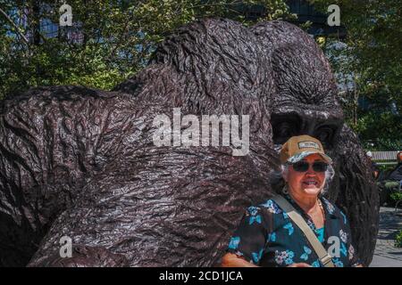 New York, USA. 25th Aug, 2020. Tourist poses next to massive gorilla sculpture by Gillie and Marc Schattner in Hudson Yards' Bella Abzug Park. The new work, titled King Nyani (Swahili word for gorilla) is able to impressively fit two to three humans inside its hand. Credit: John Nacion/SOPA Images/ZUMA Wire/Alamy Live News Stock Photo