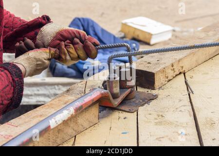 Bending reinforcement metal rebar. Worker using bending rebar machine for reinforcement in the construction work Stock Photo