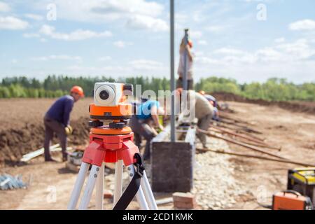 Construction equipment. Surveyors equipment theodolite on the construction site. Monitoring the progress of construction work. Stock Photo