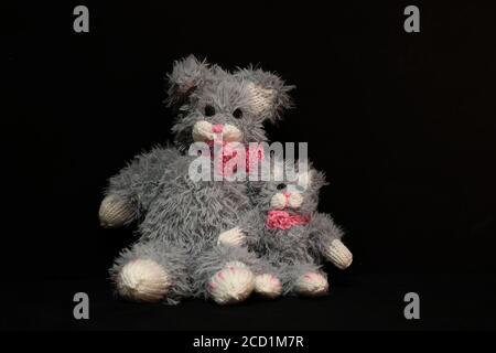 Closeup of two knitted gray bears on a black background Stock Photo