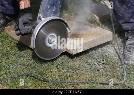 Industrial construction worker using a professional angle grinder Stock Photo