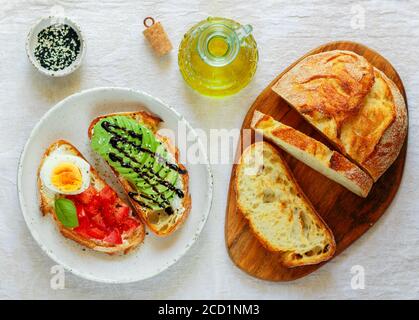 Wheat bread sandwiches with cream cheese (ricotta), avocado, eggs, tomato, Basil, black and white sesame, balsamic. Delicious healthy Breakfast for go Stock Photo