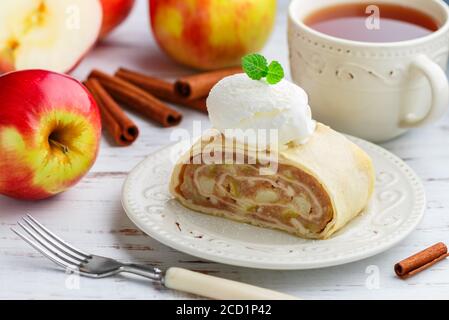 Strudel with Apple and cinnamon. Traditional layered homemade pie with fruit filling, served with powdered sugar and vanilla ice cream. Delicious dess Stock Photo