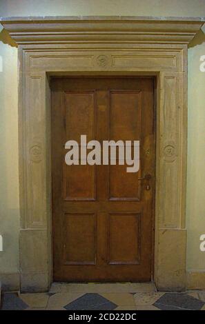 An old wooden door with a a heavy stone frame Stock Photo