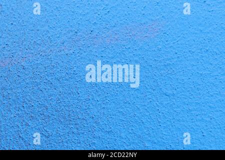 The plaster rough wall is painted blue. Stock Photo