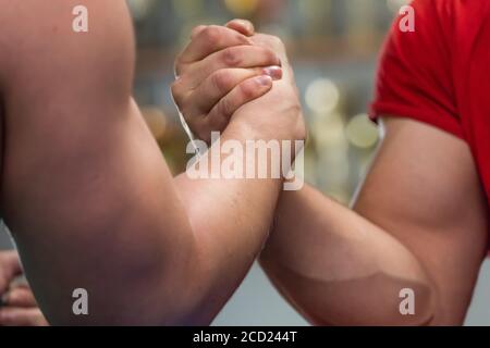 Close-up shot of strong mans' muscles during an arm-wrestling fight